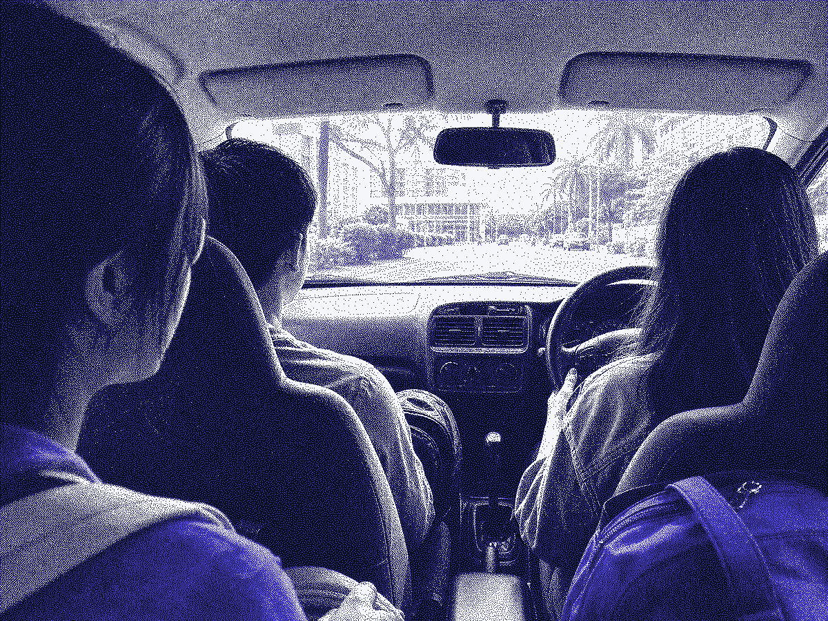 Three students sharing a campus carpool ride, seen from the back seat